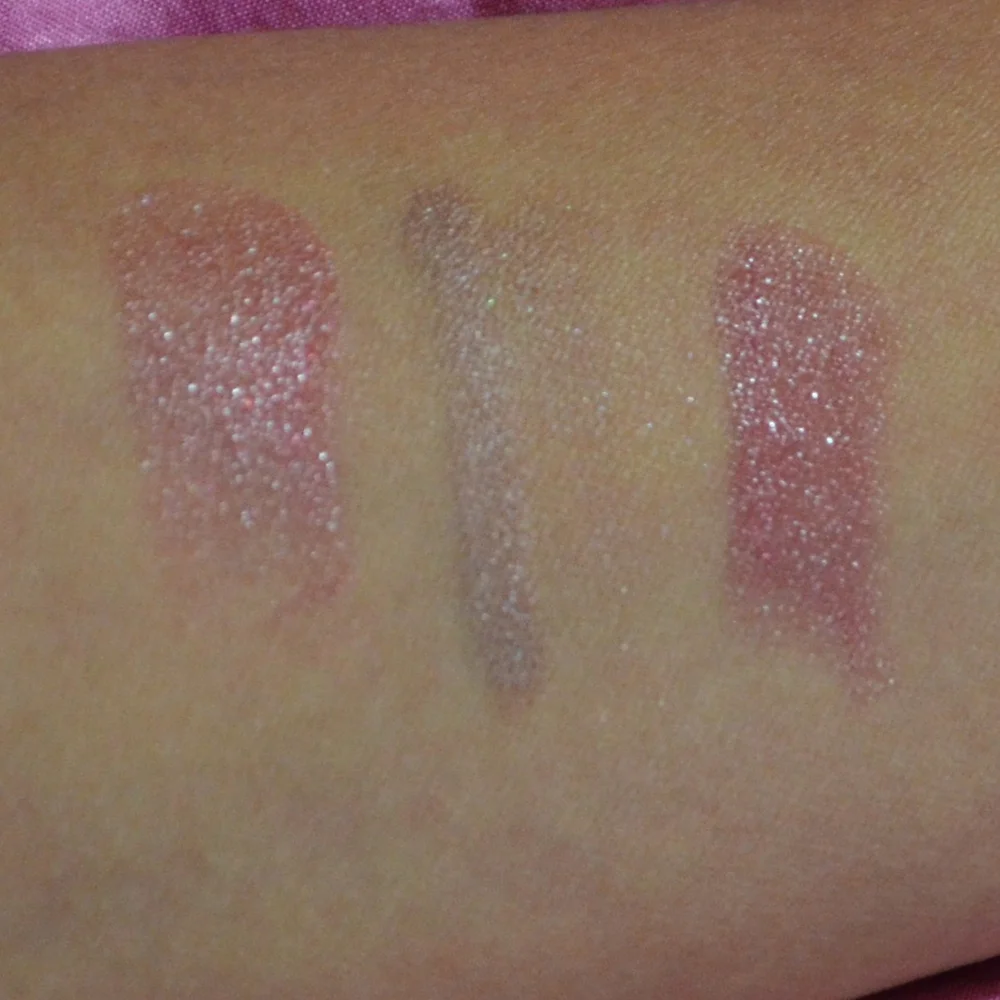 Close-up of shimmery pink and silver makeup swatches on skin